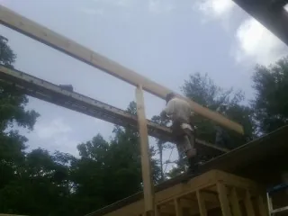 Carpenter setting a ridge beam over a new addition frame — Ice Dam Removal by Roofing Brothers in Alabaster