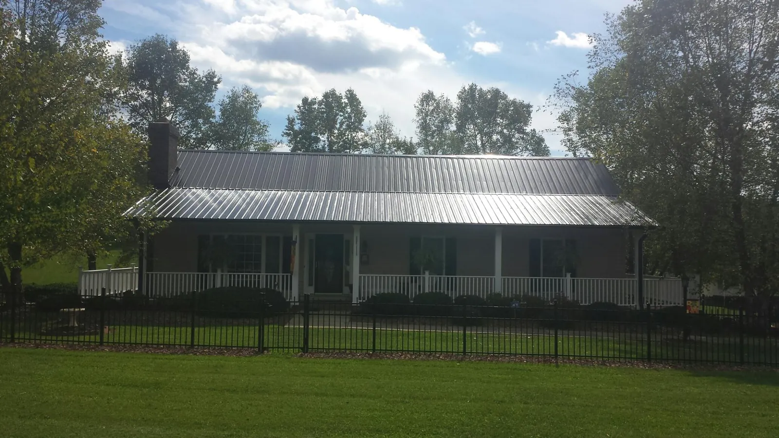 Gray metal roof on a brick ranch with a full width front porch — Gutter Guard Installation work by our crew in Alabaster