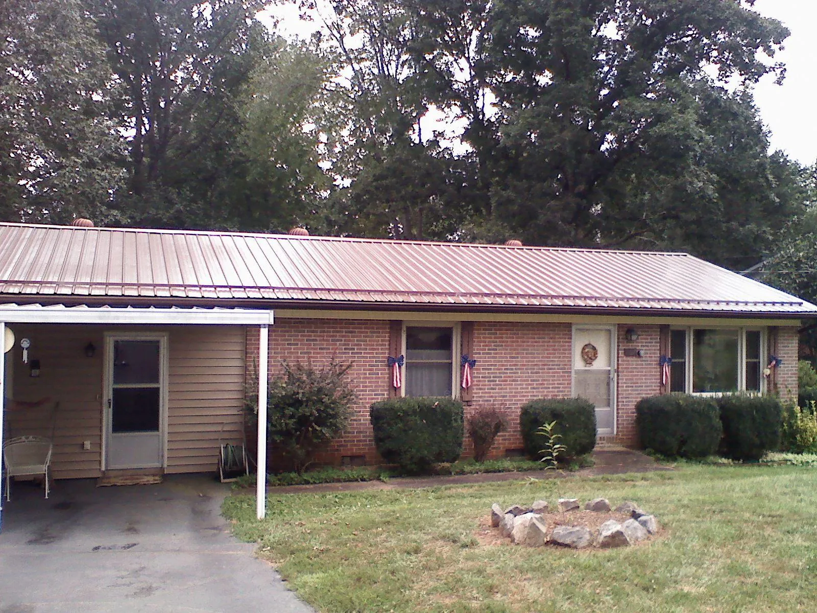 Bronze metal roof and carport on a brick ranch home — Roof Repair work by our crew in Alabaster