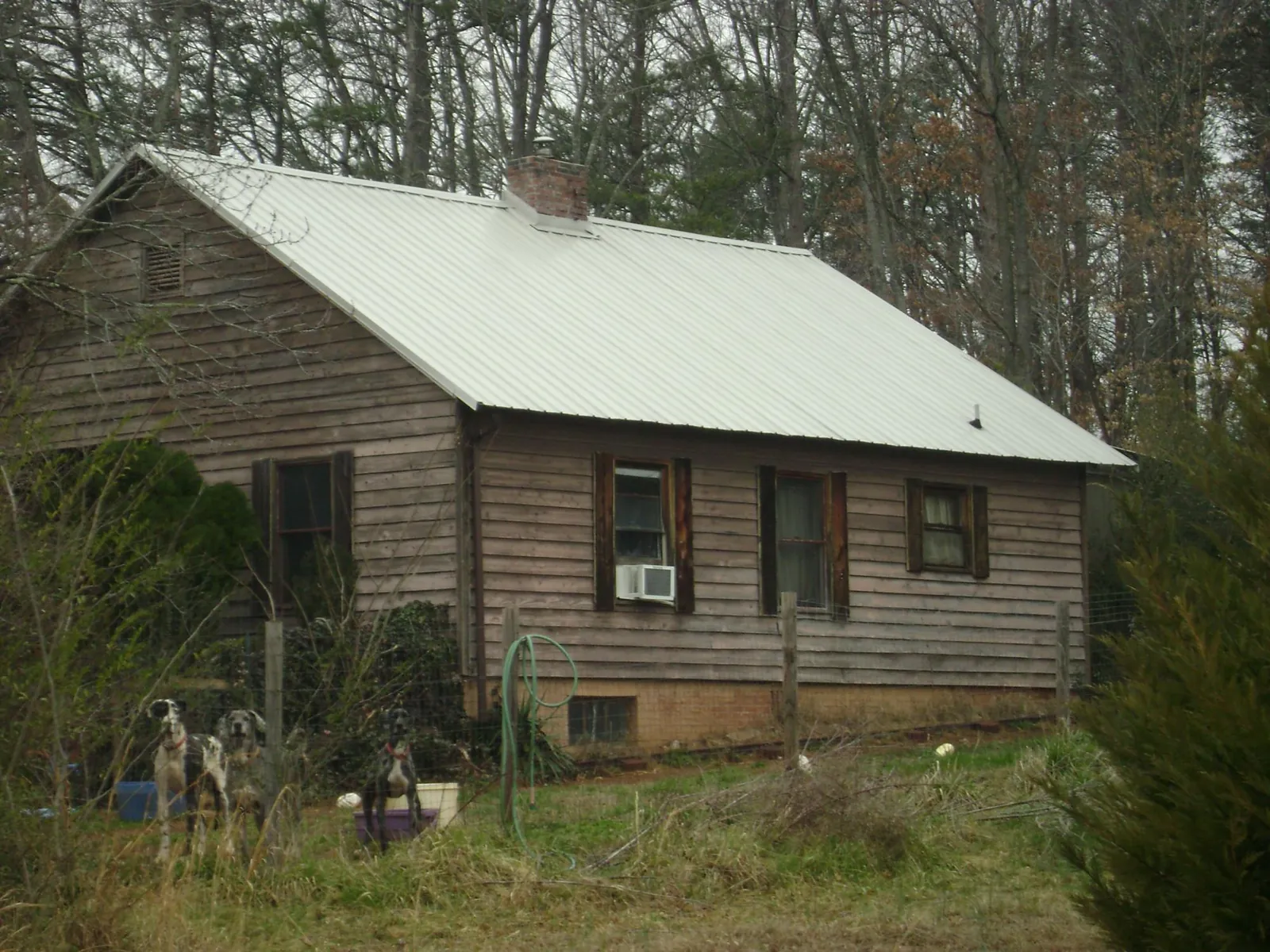 White metal roof on an old wood sided farmhouse, from a Asphalt Shingle Roof Repair job in Alabaster